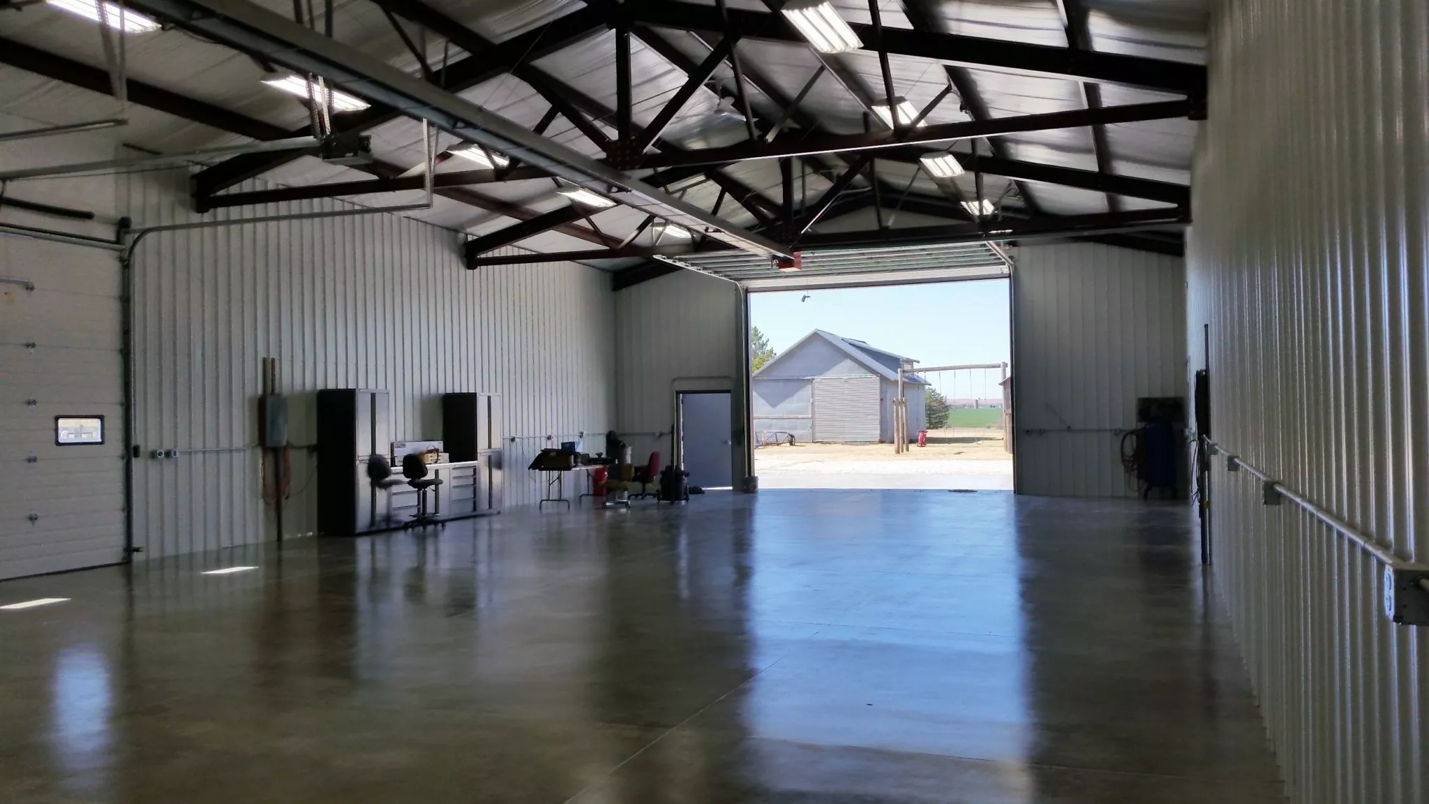 [A crimson red 40x40x16 garage with enclosed lean-to features white trim and large overhead doors.